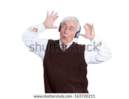 Closeup portrait of an elderly man, senior executive, retired guy, grandpa with headphones listening to the radio, enjoying music and his life, isolated on a white background. Positive human emotions