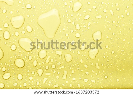 Drops of water on a color background. Selective focus. Yellow.