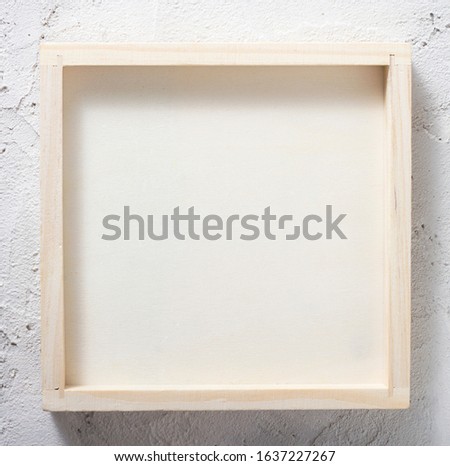 Wooden frame, box on a concrete wall. Place for your text, logo, photo. Abstract background