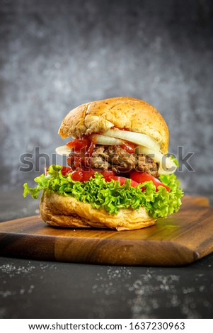 Pork burger, delicious fresh tomato sauce on a black wooden table