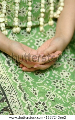 close up picture of bride's hands during "Siraman" ( ceremony of bathing a bride prior to the wedding on Javanese Culture in Indonesia).