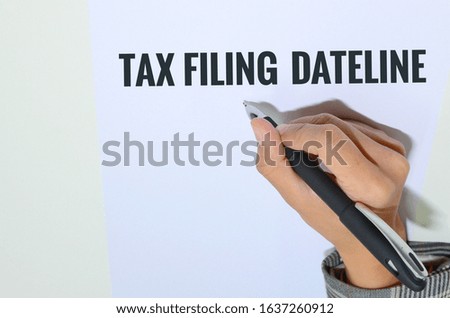 Conceptual photo using hand and pen to depict tax related matters 