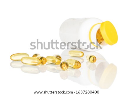 Lot of whole golden fish oil with white plastic bottle isolated on white background
