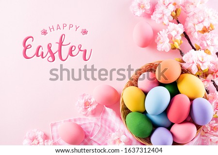 Happy easter! Colorful of Easter eggs in nest with flower and Feather on bright pink pastel paper background.
