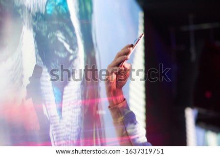 guy takes pictures on the phone in the club