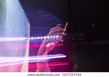 guy takes pictures on the phone in the club