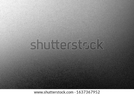 Ground glass texture with light with blur effect in black and white. Abstract background and pattern for designers.