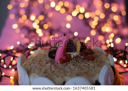 Burning candle in a cake festive background