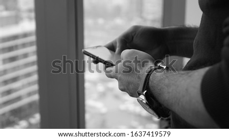 man holding phone in hand. back and white close up telephone, smartphone