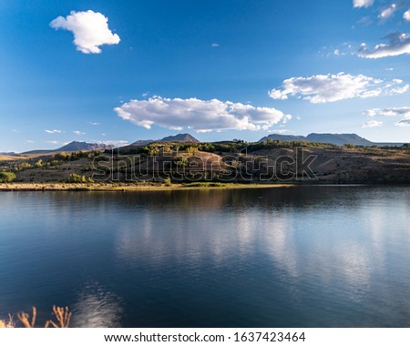 A beautiful Colorado view across Green Mountain Reservoir, to mountains in the distance. Reflections of clouds in the water. Concepts of travel, water conservation, resource management
