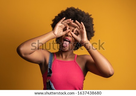 afro girl making funny faces on colorful background