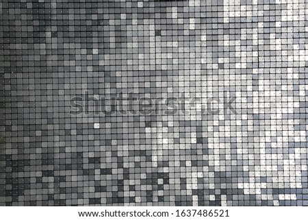 Sequin background. Silver square sequins shimmering in the sun. Reflecting colors of the rainbow including blue, gray, silver, green, black, red, yellow and more. Backgrounds and Textures. Photo Booth