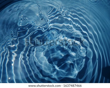 The abstract​ of metal​ texture​ on​ the​ surface​ blue​ water​ for​ background. Blue​ water​ texture​ reflected​ with​ sunlight​ for​ background​