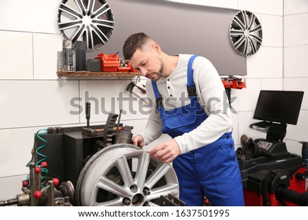 Mechanic working with car disk lathe machine at tire service