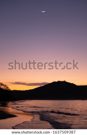 Sunset on Del Coco Beach in Costa Rica with the moon shining above