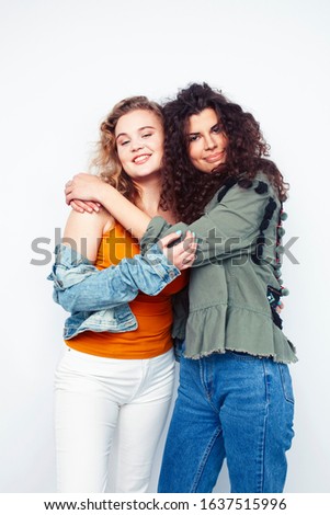 young pretty teenage girls friends with blond and brunette curly hairs posing cheerful isolated on white background, lifestyle people concept
