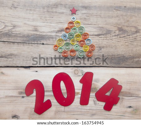 word 2014 and curling paper Christmas tree on wood background