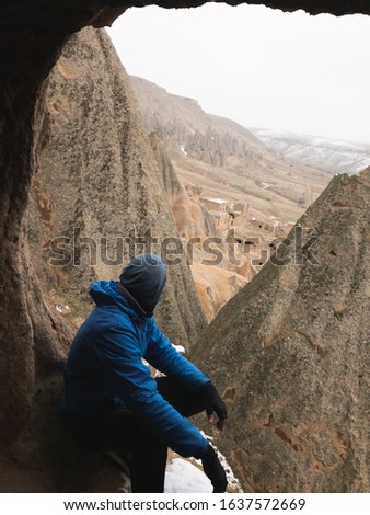 Tourist look down from the cave to fairy chimneys in Selime. Cappadocia. Concept of travel and exploration in winter.Selime monastery. 2019 december.
