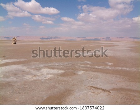 Landscape picture of Sahara dessert and drying lake with cloudy blue sky in hot enviroment, Tunisia
