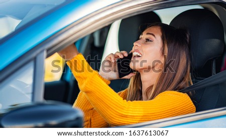 Talking on the phone while driving. Texting and driving. Distracted driver behind the wheel. Beautiful female Driver talking on the Phone. Young woman talking on phone while driving car