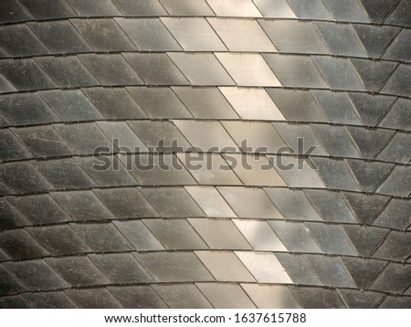 The surface is made of shiny metal plates. Background
