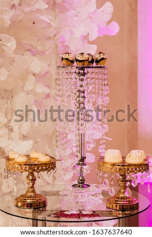 Wedding cupcakes. Party table graduation decoration. Sweet cakes on a buffet table. Delicious candy bar with cake pops. White and gold style, beautiful design.