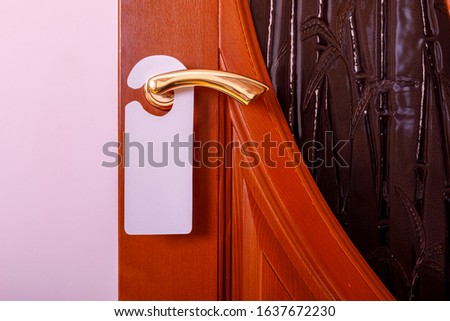 Do not disturb sign at the door. Empty label or flyer on a door handle for your text.