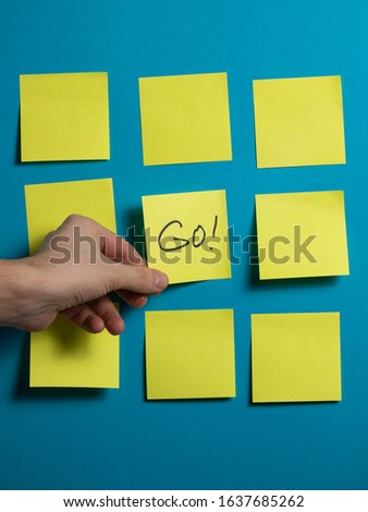 hand take yellow sticker that says GO. motivating banner. empty space for text