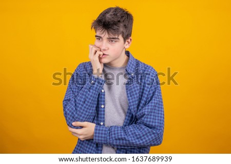 young teenager boy or student isolated on yellow background