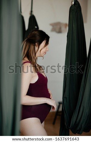 Pregnant girl. Woman doing hammock yoga. Concept of healthy lifestyle, fitness,  happyness. Motherhood.