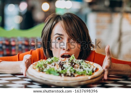 Young pretty woman eating pizza at pizza bar