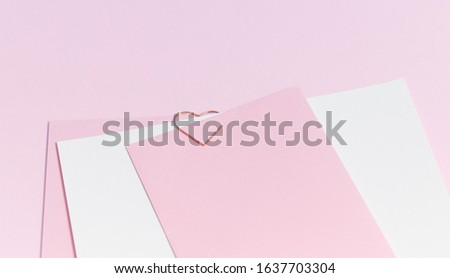 Empty template for romantic letters on a pink background. White feather with gold plating. Real photo, flat lay. Copy space for text.
