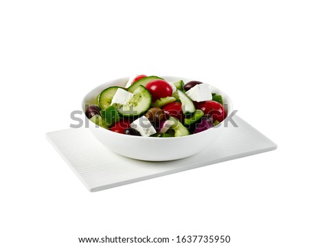 Food photography of a Greek salad in a white bowl on a white background