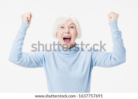 Excited mature lady feel euphoric and winning isolated on white studio background