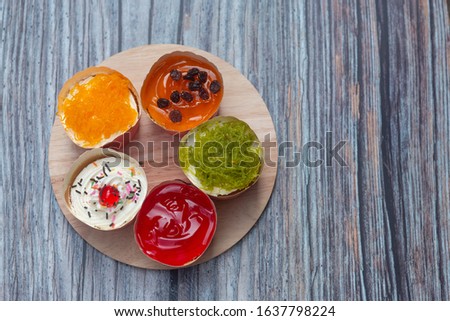  Beautiful cupcakes on wooden background, closeup.