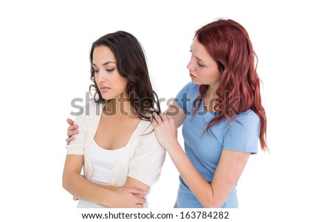 Young woman consoling female friend over white background