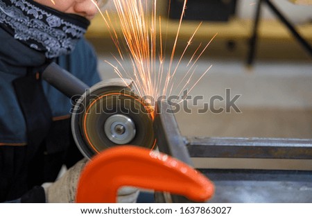cutting metal pipe with sparks with a cutting disc in the workshop with copy space