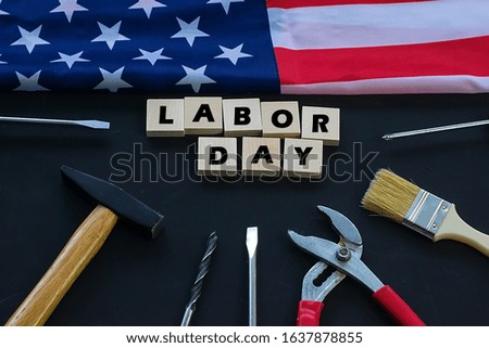 USA Labor Day. Different tools and american flag on a black background