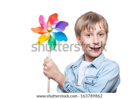 Beautiful cheerful blond boy wearing stylish shirt holds a colorful pinwheel smiling (isolated on white)
