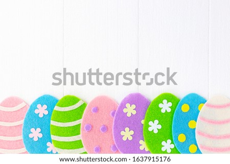 Cute white Easter holiday photo background with colorful handmade eggs.