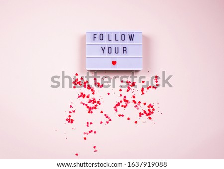 Words fallow your on the light box on a dark background, with little hearts. Place for text, abstract content.