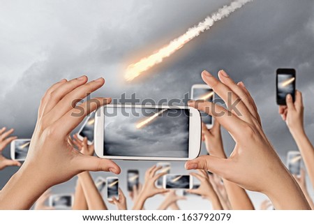 People taking photos of falling meteorite on mobile phone camera