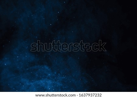 A deep blue starry mist over a black backdrop. 