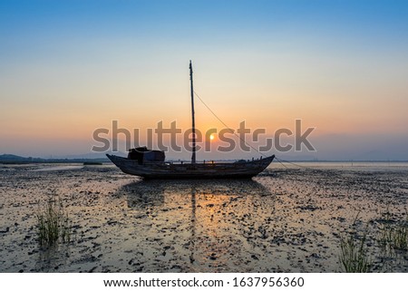 Fishing boats on the beach, sunset, clouds and sand make up a beautiful picture