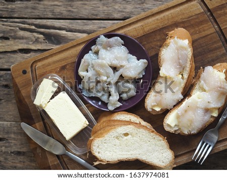 Breakfast, lunch, snack. Sandwiches with butter and freshly salted fish pike on a cutting kitchen board. XE fish salad. Wooden ancient background. Royalty-Free Stock Photo #1637974081