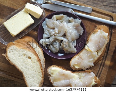 Breakfast, lunch, snack. Sandwiches with butter and freshly salted fish pike on a cutting kitchen board. XE fish salad. Wooden ancient background. Royalty-Free Stock Photo #1637974111