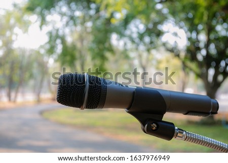 Outdoor microphone.One black microphone.A black microphone on the lawn and the road Royalty-Free Stock Photo #1637976949
