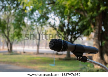 Outdoor microphone.One black microphone.A black microphone on the lawn and the road Royalty-Free Stock Photo #1637976952