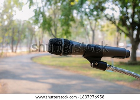 Outdoor microphone.One black microphone.A black microphone on the lawn and the road Royalty-Free Stock Photo #1637976958