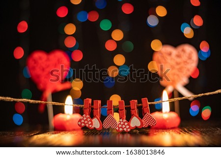 Valentine's day, romantic still life, burning candles, clothespins, hearts on a blurred background, bokeh effect, shallow depth of field. Beautiful holiday picture.